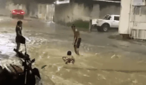 VÍDEO: durante chuva, crianças praticam ‘surf’ em rua alagada de Manaus
