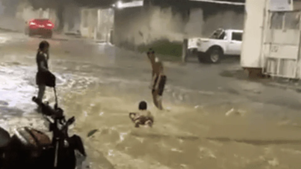 VÍDEO: durante chuva, crianças praticam ‘surf’ em rua alagada de Manaus