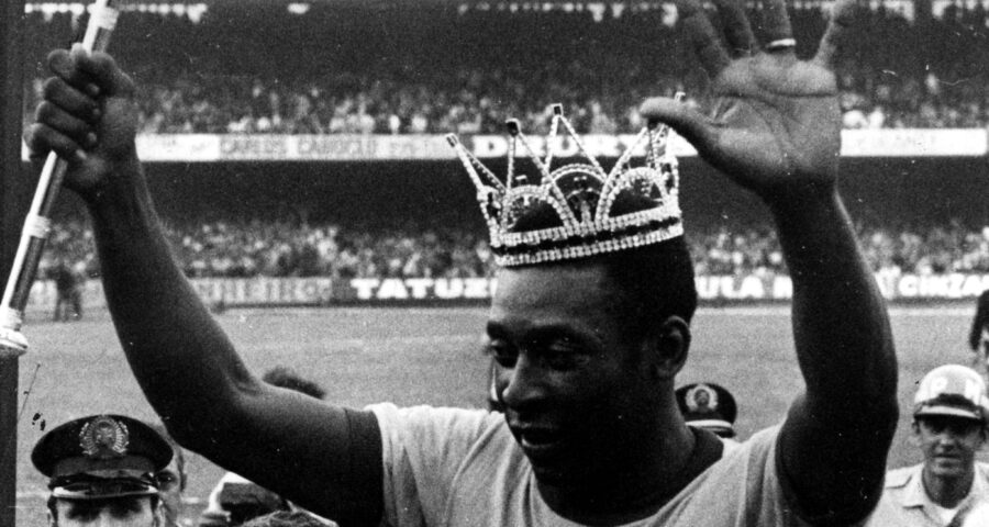 Com uma coroa na cabeça e um cetro na mão, Pelé acena para o público ao deixar o campo em sua despedida da Seleção Brasileira em São Paulo, no dia 11 de julho de 1971 - Foto: Domício Pinheiro/Estadão Conteúdo