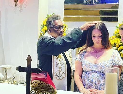 Lana Del Rey foi até uma igreja católica, onde foi abençoada por um padre. O momento de fé da norte-americana foi registrado em fotos - Foto: Reprodução/Twitter: @lanabrasil