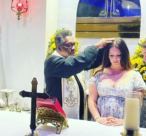 Lana Del Rey foi até uma igreja católica, onde foi abençoada por um padre. O momento de fé da norte-americana foi registrado em fotos - Foto: Reprodução/Twitter: @lanabrasil