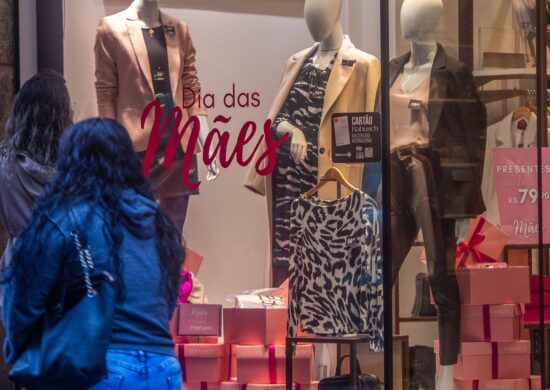 Pedestres passam por vitrines de lojas com promoções para o Dia das Mães no centro de Porto Alegre - Foto: Evandro Leal/ Enquadrar/ Estadão Conteúdo