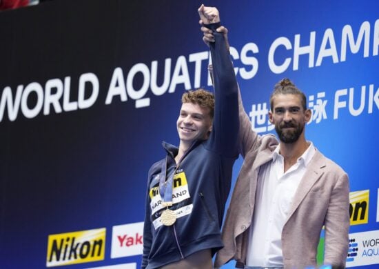 O francês Leon Marchand recebe do ex-nadador americano Michael Phelps a medalha de ouro dos 400m medley da Natação no Mundial de Esportes Aquáticos 2023, em Fukuoka, no Japão - Foto: Eugene Hoshiko/ Associated Press/ Estadão Conteúdo