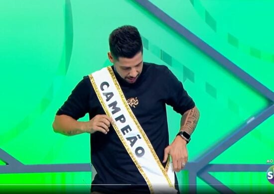 Comentarista Cicinho veste faixa de campeão e polemiza durante programa - Foto: Reprodução/SBT