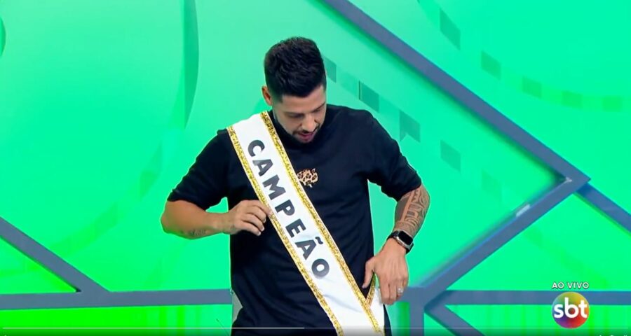 Comentarista Cicinho veste faixa de campeão e polemiza durante programa - Foto: Reprodução/SBT