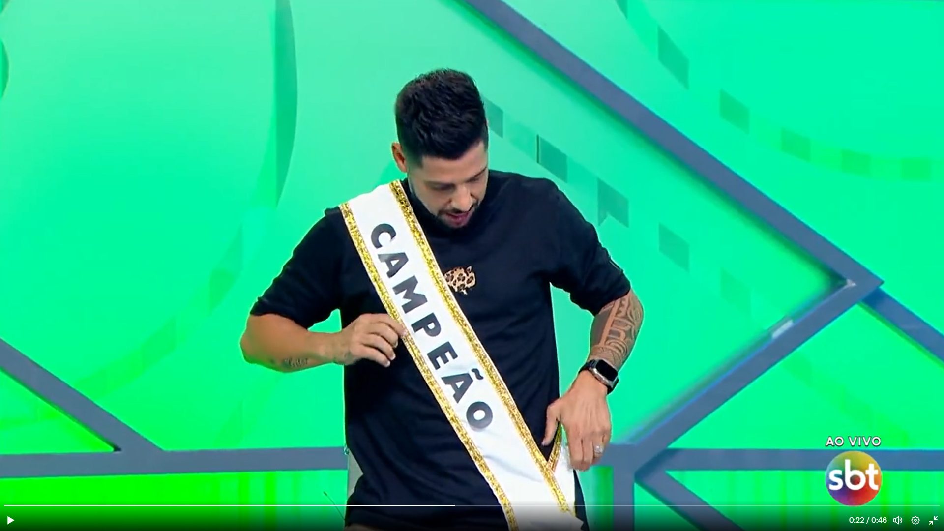 Comentarista Cicinho veste faixa de campeão e polemiza durante programa - Foto: Reprodução/SBT