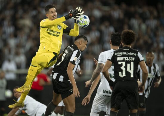 Tiquinho Soares disputa lance com Tadeu jogador do Goiás