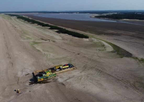 Balsa que transportava veículos e botijões de gás, encalhada em um banco de areia no Rio Negro, em Manaus, devido à seca severa que afeta a região - Foto: Edmar Barros/Futura Press/Estadão Conteúdo