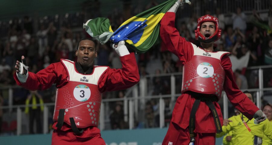 Maicon de Andrade Siqueira e Edival Marques Quirino Pontes, do Brasil, comemoram a conquista da medalha de ouro no taekwondo masculino por equipes dos Jogos Pan-Americanos de Santiago 2023 - Foto: Dolores Ochoa/Associeated Press/ Estadão Conteúdo