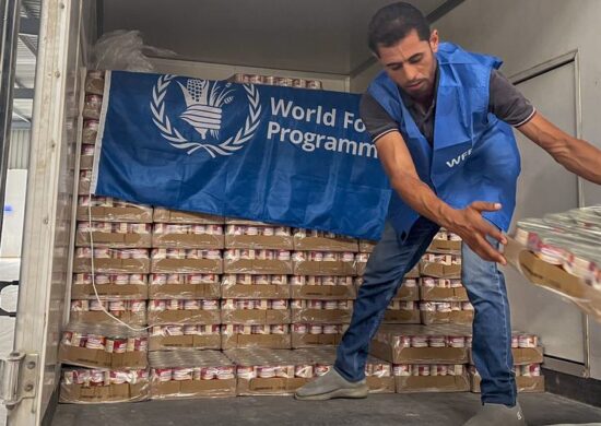 Um trabalhador descarrega alimentos prontos para consumo de um caminhão perto de Alexandria, no Egito, em preparação para entrega em Gaza - Foto: PMA/Amira Moussa