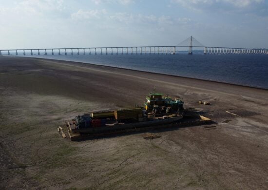 Balsa que transportava veículos e botijões de gás de cozinha, é vista encalhada em banco de areia no Rio Negro, devido à seca severa - Foto: Edmar Barros/Futura Press/Estadão Conteúdo