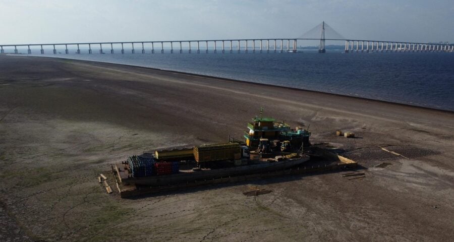 Balsa que transportava veículos e botijões de gás de cozinha, é vista encalhada em banco de areia no Rio Negro, devido à seca severa - Foto: Edmar Barros/Futura Press/Estadão Conteúdo