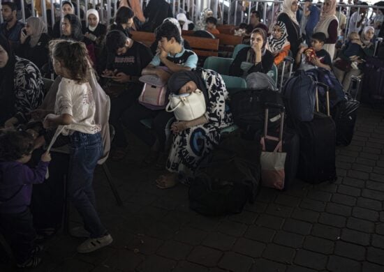 Palestinos e trabalhadores humanitários estrangeiros esperam para cruzar para o Egito em Rafah, na Faixa de Gaza - Foto: Fatima Shabair/ Associeated Press/ Estadão Conteúdo