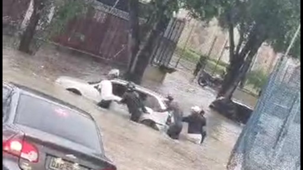 Situação do carro na rua alagada ocorreu durante chuva nesta manhã - Foto: Reprodução/WhastApp