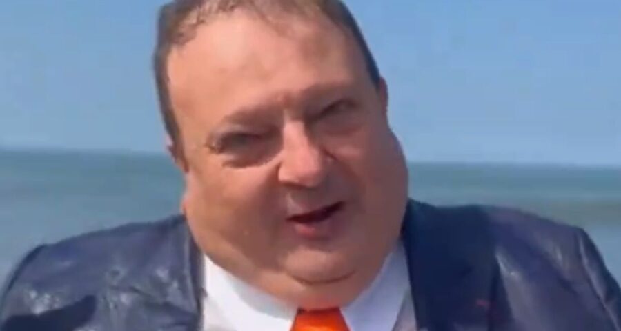 No vídeo, o chef aparece de terno na praia