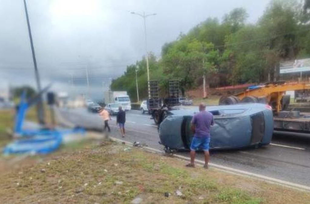 Carro capota, atinge ponto de ônibus