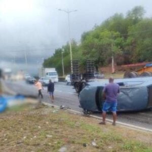 Carro capota, atinge ponto de ônibus