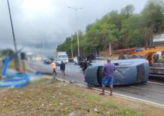 Carro capota, atinge ponto de ônibus