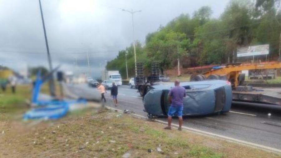 Carro capota, atinge ponto de ônibus