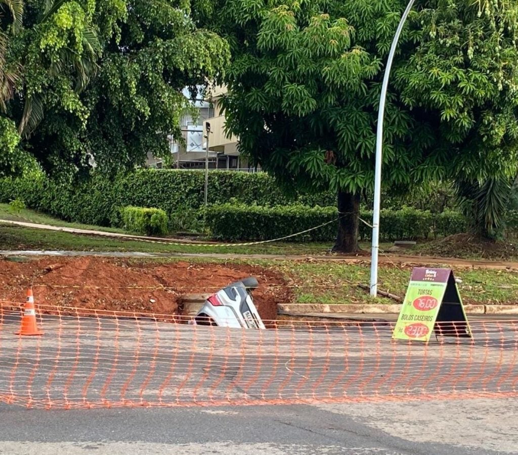 Asfalto cede e carro é engolido por cratera em Brasília.