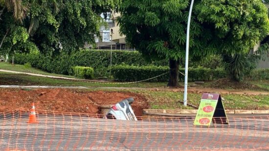 Asfalto cede e carro é engolido por cratera em Brasília.